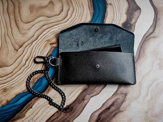 Delilah Clutch in black pebbled leather shown with detachable chain strap and matching gunmetal wristlet.