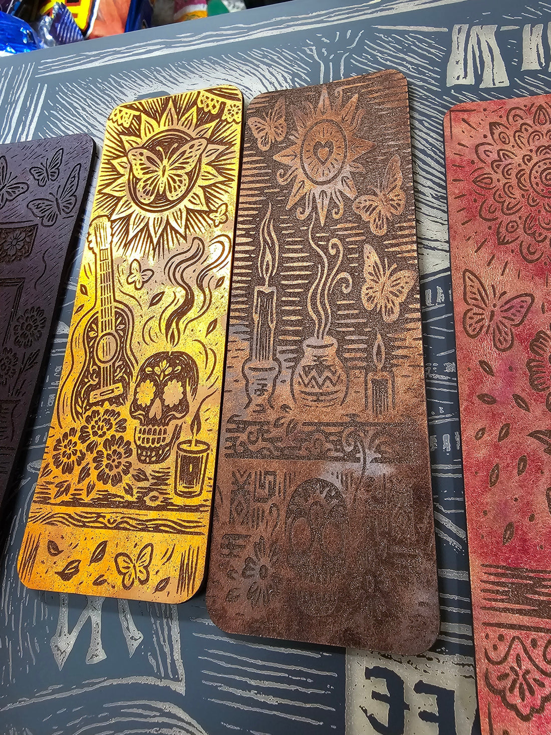 Series of engraved metallic leather bookmarks demonstrating how imagery changes when translated from digital design into physical material.