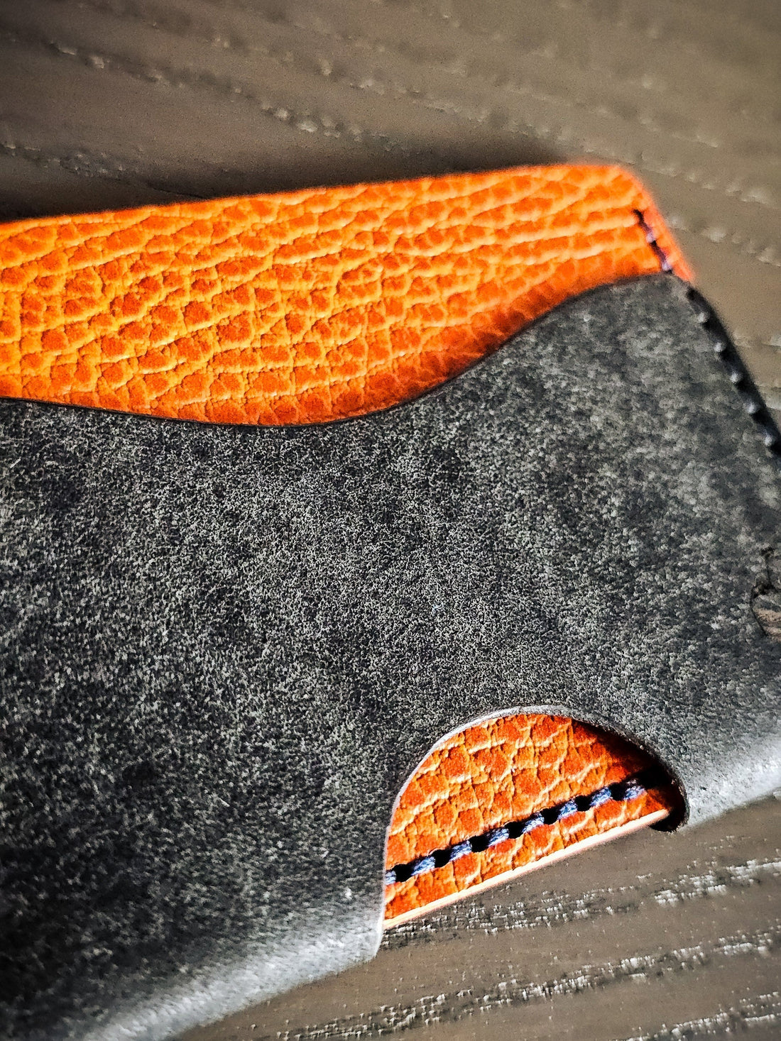 Close-up of a leather card pocket showing layered construction and recurring design elements used throughout the studio's carry systems.