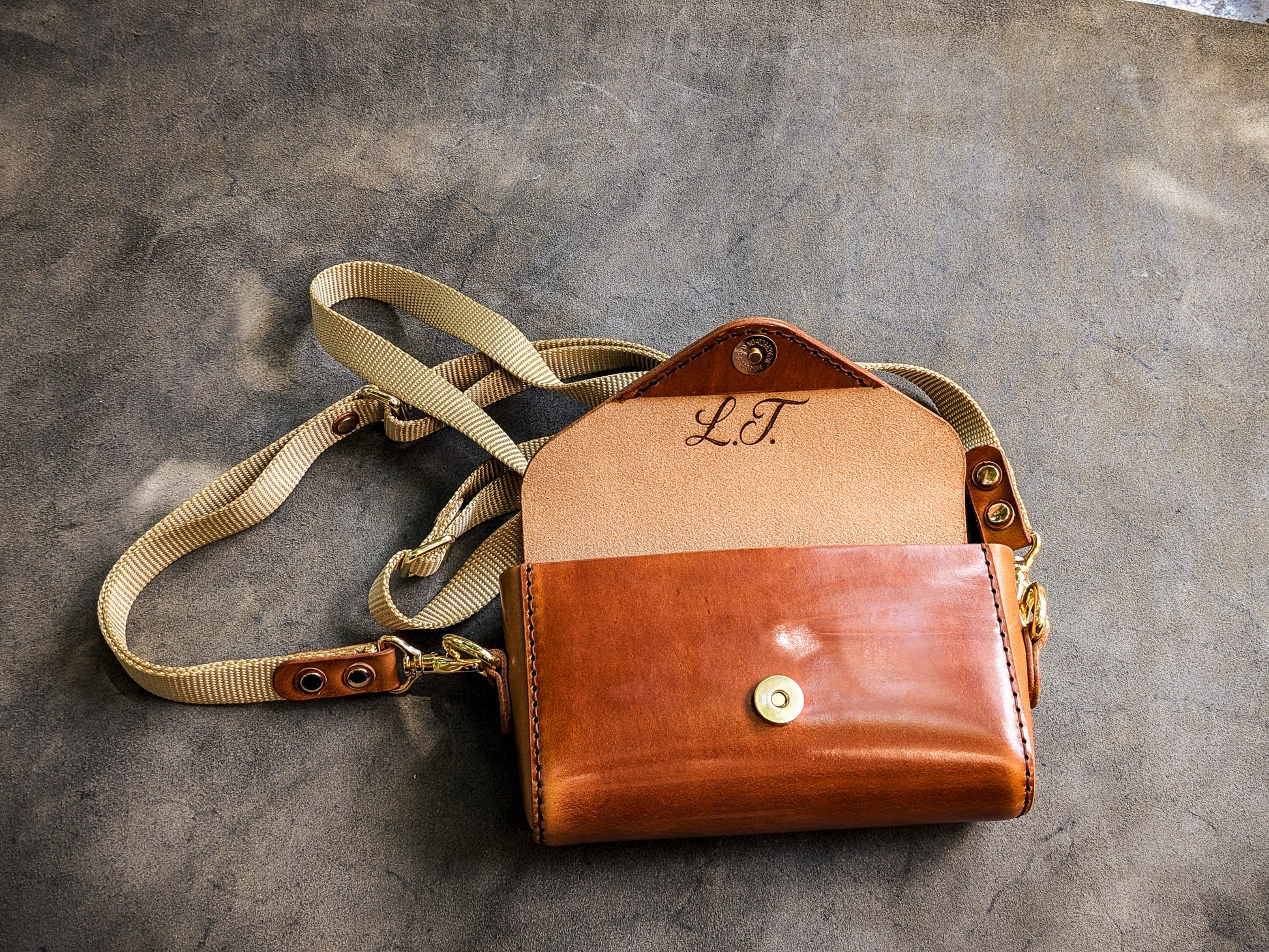 Open Renee crossbody bag displaying the leather-lined interior, organizational pockets, and storage compartments.