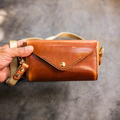 Hand holding the Renee crossbody bag to demonstrate size, proportions, and everyday carry capacity.