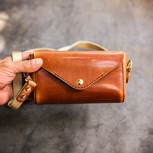 Hand holding the Renee crossbody bag to demonstrate size, proportions, and everyday carry capacity.