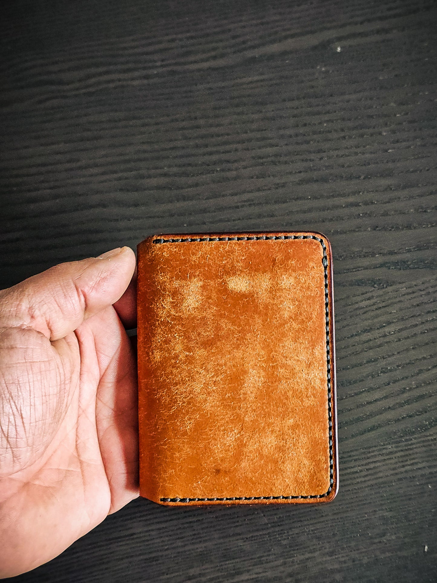 Eastland leather bifold wallet shown closed in hand for size reference