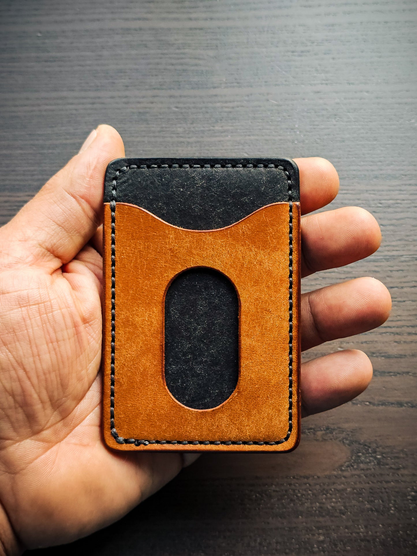 Sidekick leather cardholder shown in hand with rear thumb access cutout