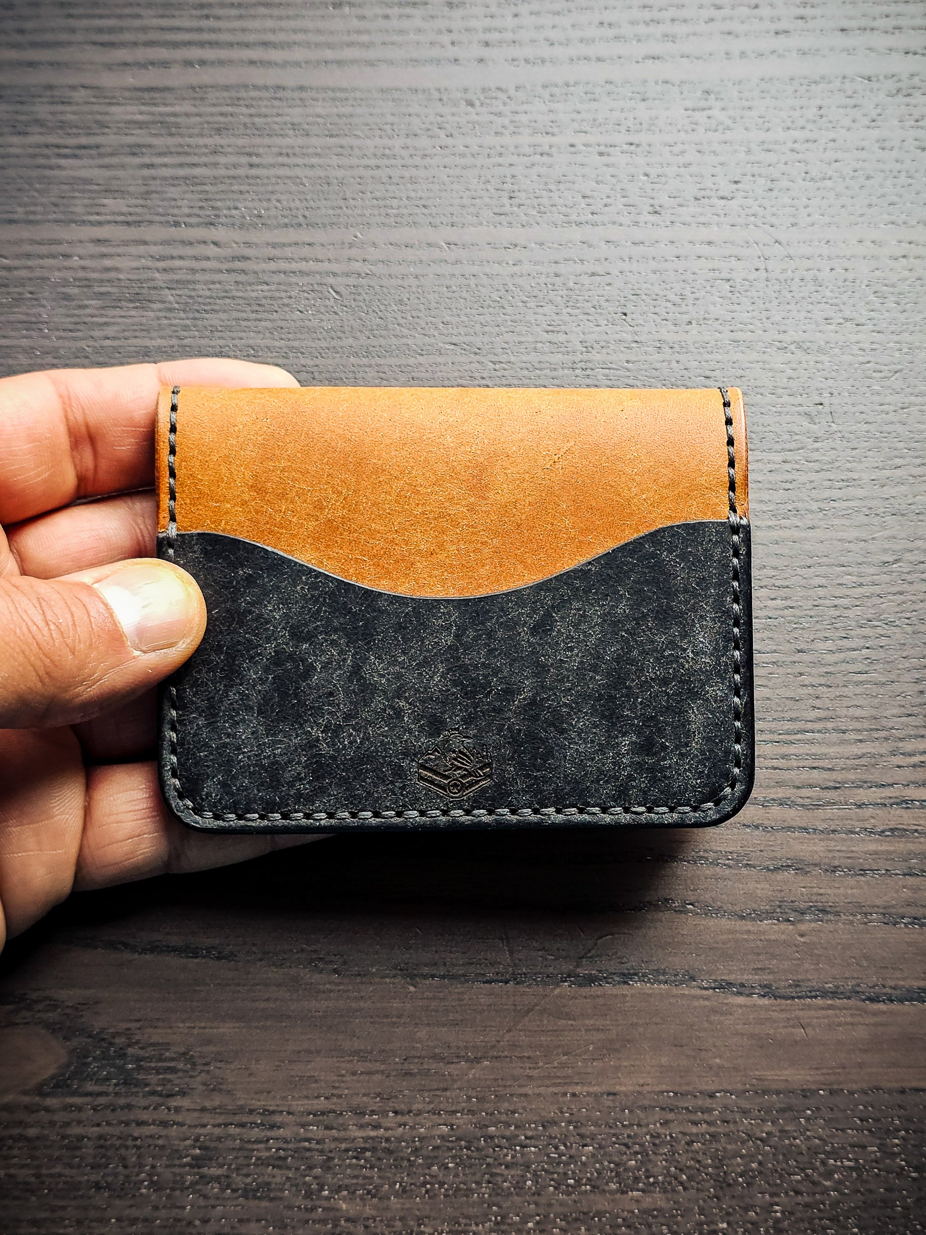Westfield leather bifold wallet shown closed in hand for size reference