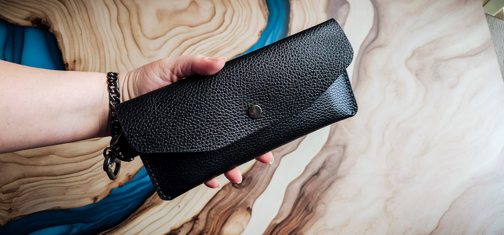 Delilah Clutch held in hand to demonstrate size, carry style, and handcrafted construction.