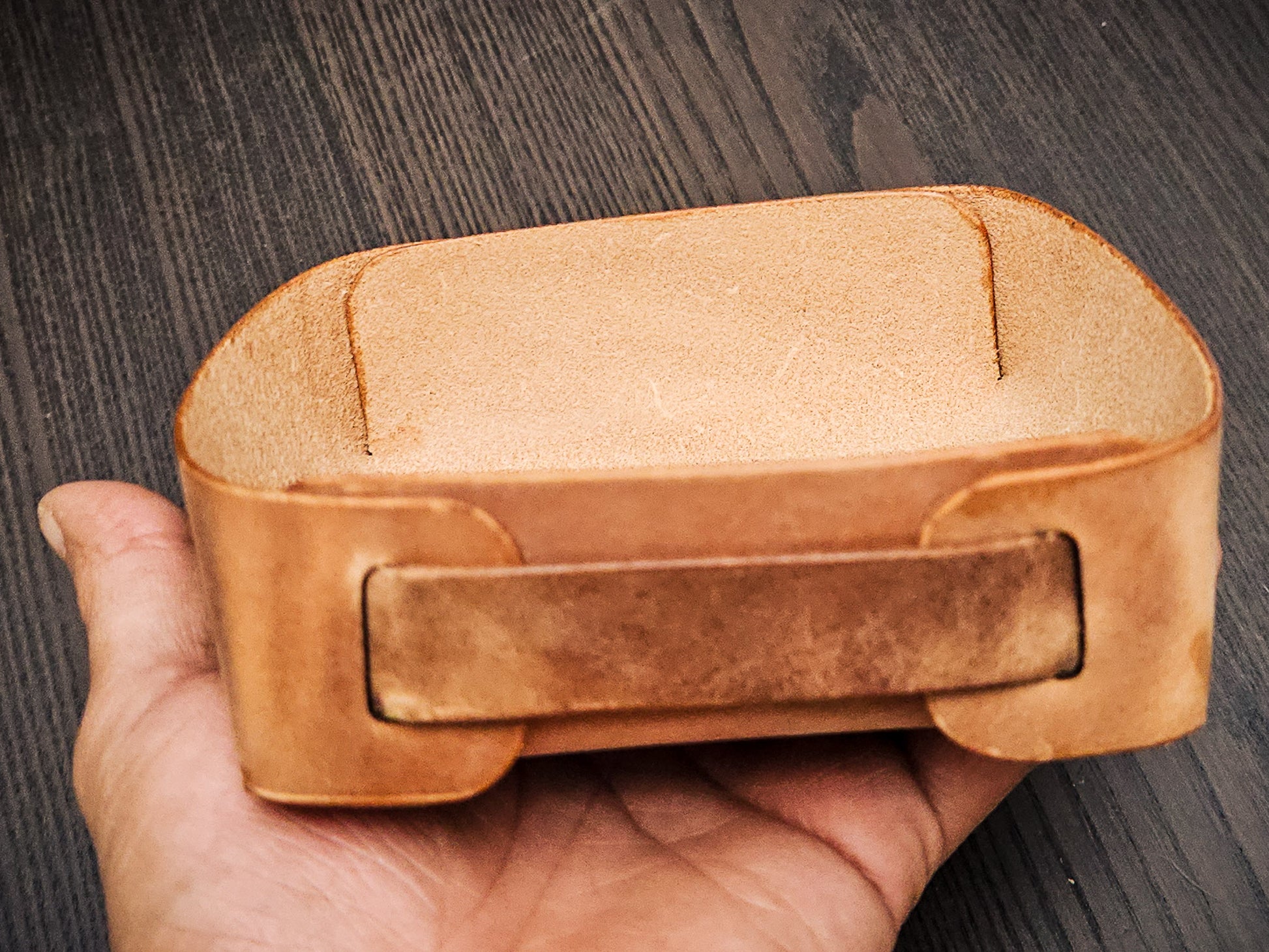 The Nest leather valet tray holding everyday carry items including sunglasses, notebook, wallet, pen, and accessories in a compact catchall design.