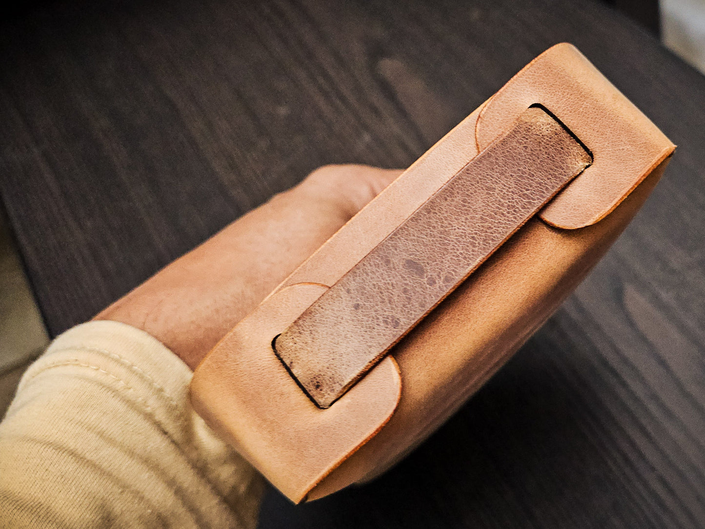 Side view of The Nest leather valet tray displaying folded leather architecture, layered construction, and integrated handle detail.
