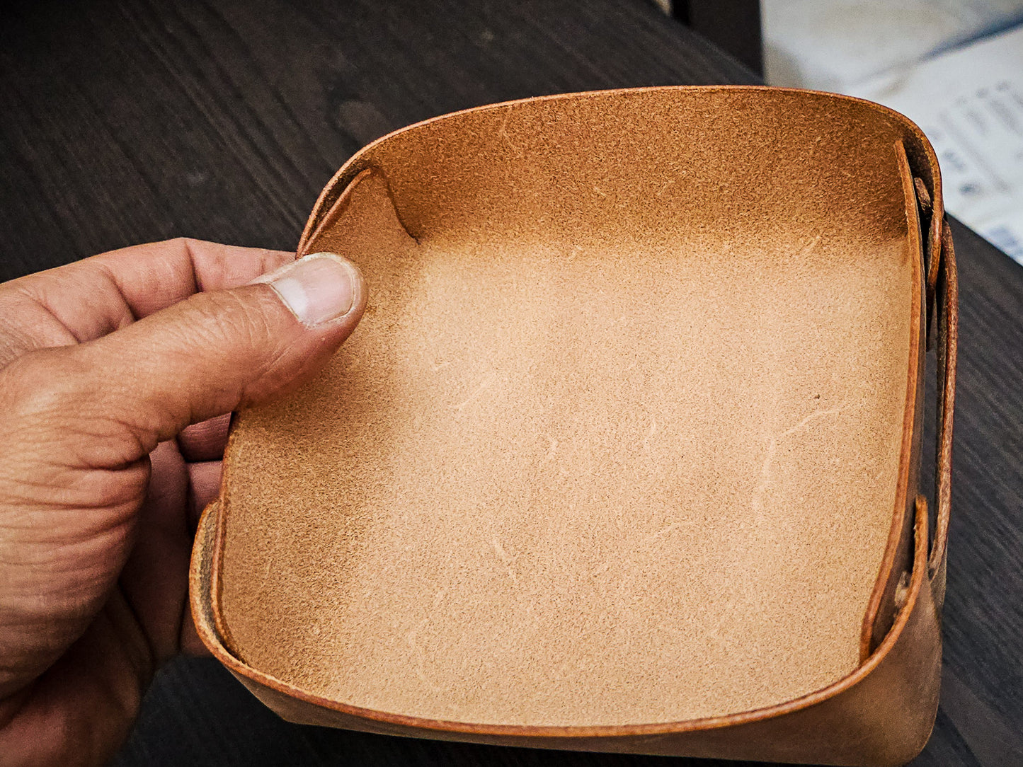 The Nest leather valet tray held in hand to demonstrate size, proportions, and compact everyday carry storage capacity.